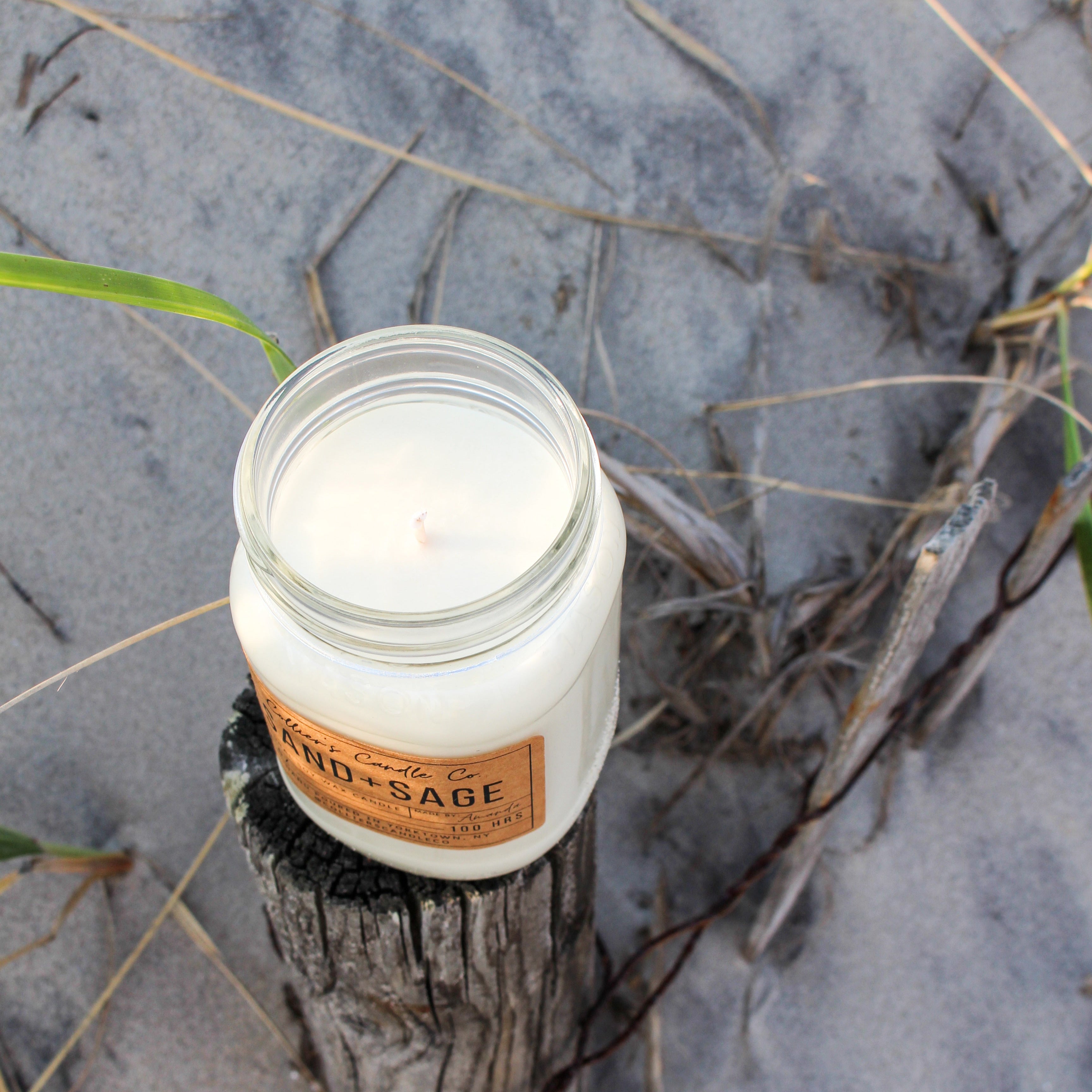 Sand + Sage candle shown on the beach